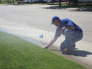 an Elk Grove Sprinkler Repair team member adjusts a sprinkler head