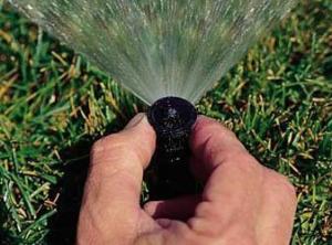 a hand adjustment of a sprinkler head